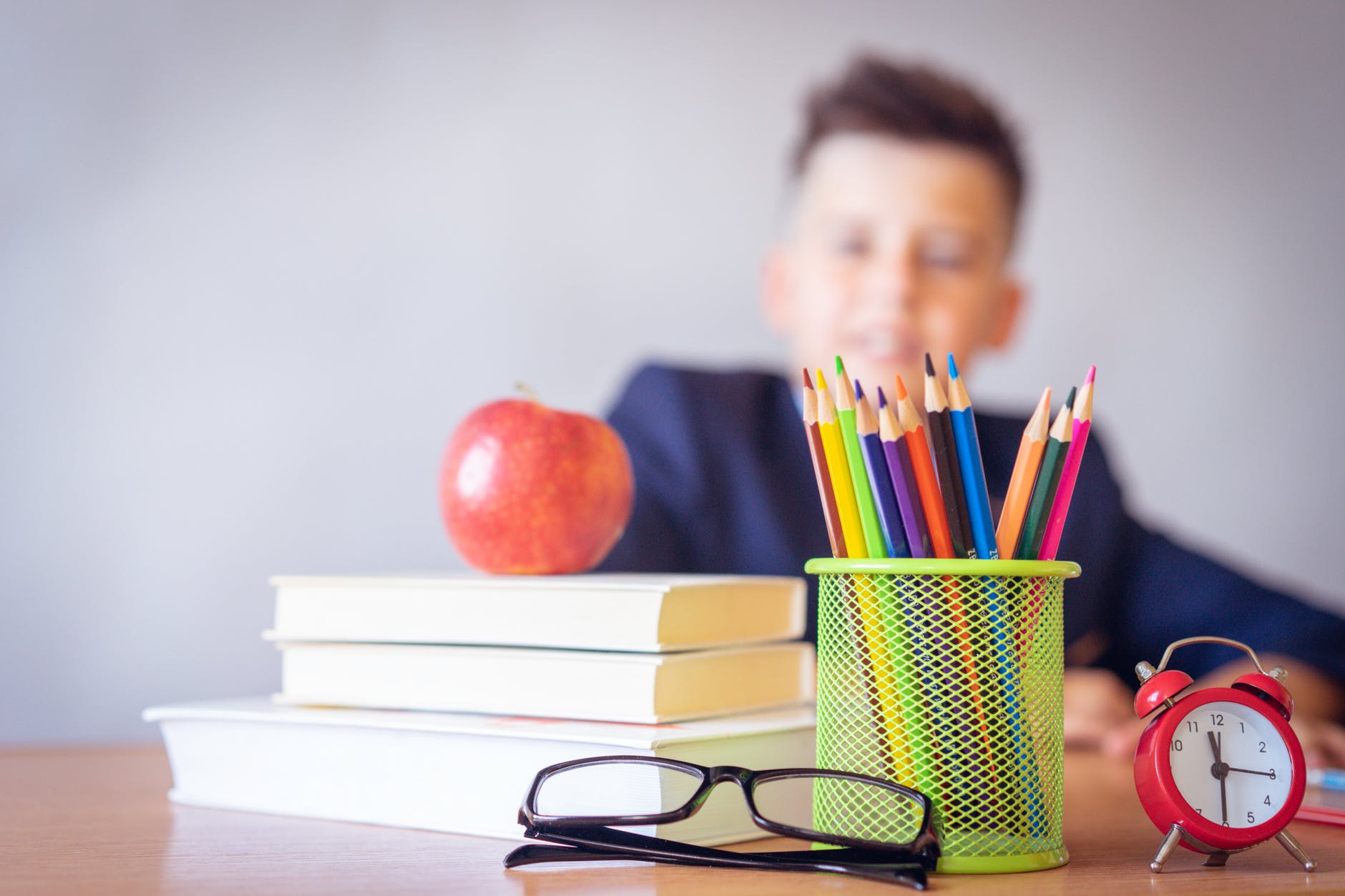 fotografía en color de un niño con varios elementos para estudiar y una montura