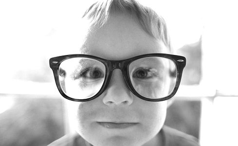 Fotografía en blanco y negro de niño con unas gafas inmensas